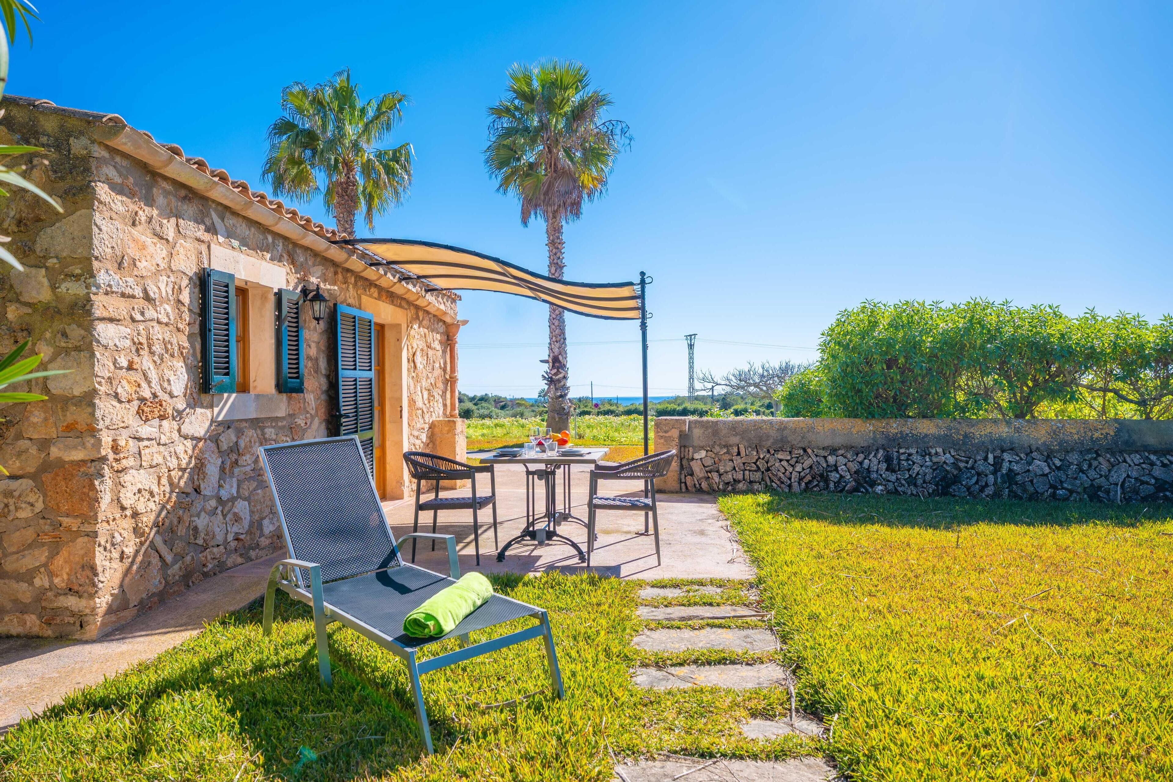 Un edificio de piedra con un patio, mobiliario exterior y vistas del paisaje.