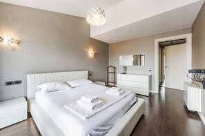 Une chambre moderne avec un grand lit, des tables de chevet, une commode et un miroir.