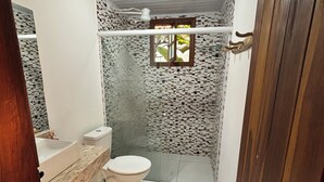 A bathroom with a toilet, sink, and shower area. - Pousada Jardim da Vida (Caeté-Açu)