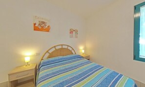 Ein Schlafzimmer mit einem Bett, zwei Nachttischen und Wanddekorationen.