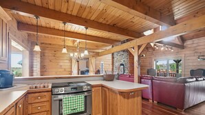 A kitchen with wooden cabinets, a stove, and hanging lights. - Experience the quiet beauty of the Amish countryside at Sprinkle Bottom Lodge. (Sullivan)