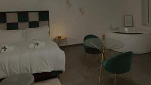 Ein modernes Schlafzimmer mit einem Bett, einem Nachttisch und einem kleinen runden Tisch mit Stühlen.