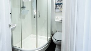 Ein Badezimmer mit Duschkabine, Toilette und Waschbecken.