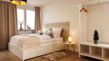 Une chambre à coucher avec un lit, une table de chevet, une lampe et un porte-manteau.