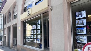 Um edifício com uma grande vitrine repleta de anúncios de imóveis.
