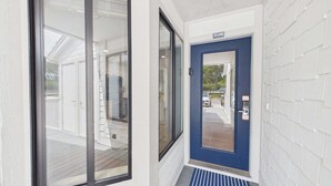 En husentré med en blå dörr, en glasdörr och en vit yttervägg.