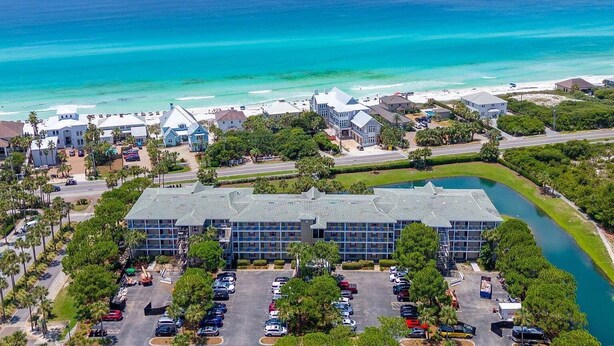 A coastal hotel with a parking lot, a swimming pool, and a view of the ocean. - Sandy Spires 403-Gulf Views-Sleeps 8 (Seagrove Beach)