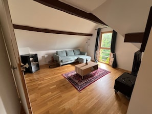 Een woonkamer met een bank, salontafel en televisie.