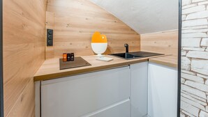 A modern kitchen with wooden cabinetry, a black sink, and a white countertop. - New Studio at the Gateway to the Alpilles with Pool and Large Garden (Noves)