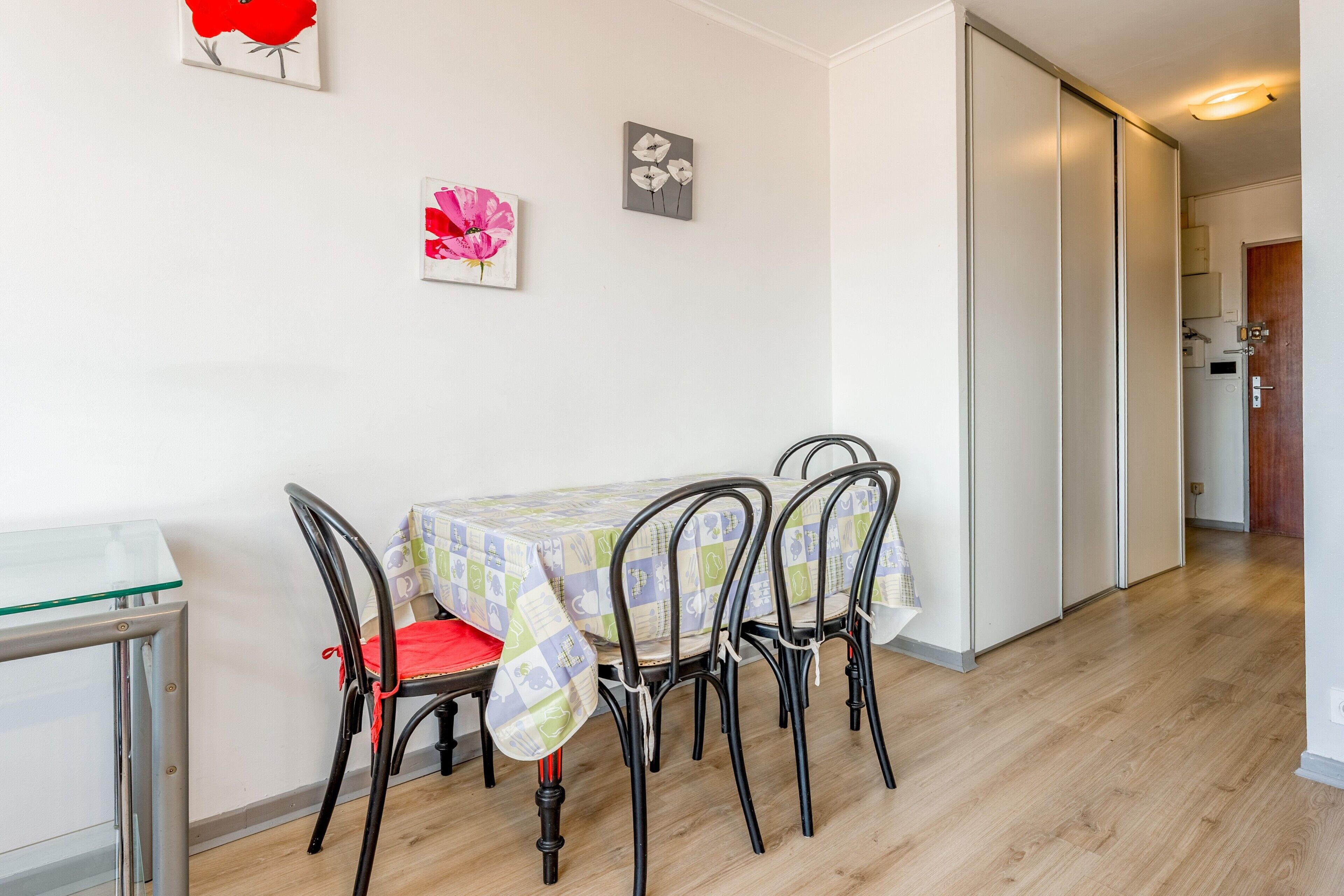 A dining area with a table, chairs, and a glass partition.