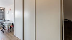 A dining area with a table and chairs, a white wall, and a door. - Cozy Studio in the Heart of Avignon (Avignon)