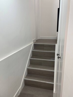 Una escala de fusta amb parets blanques.