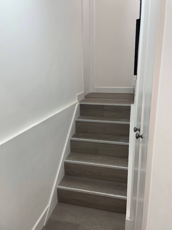 A staircase with wooden steps and white walls.