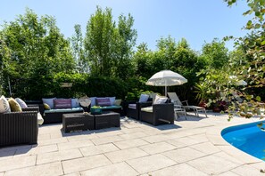 An outdoor patio with wicker furniture, a pool, and lush greenery. - Guest Room “Chambre Tulipe” with Shared Pool, Terrace, and Wi-Fi (Sélestat)