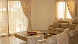 Una sala de estar con un sofá, una mesa de centro y un televisor.