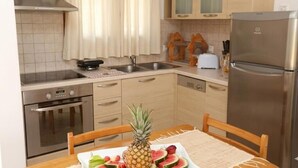Una cocina con un refrigerador de acero inoxidable, una estufa y un lavamanos.