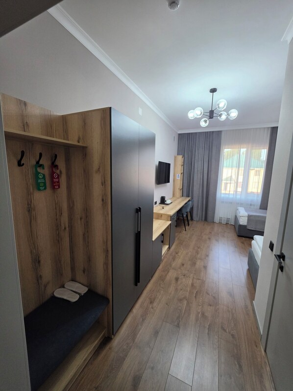 Una cocina moderna con refrigerador integrado, armarios de madera y un comedor con mesa y sillas.