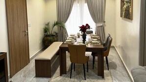 Een eethoek met een tafel voor vier personen, een bankje en een bank.