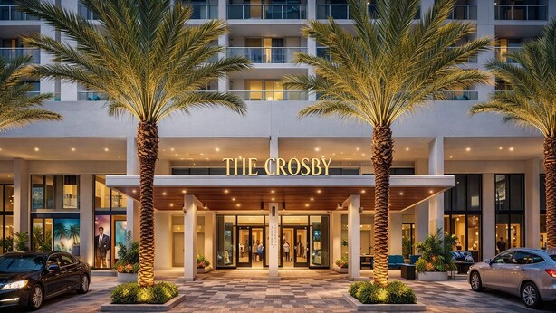 A hotel entrance with a modern facade, palm trees, and a well-lit entrance. - RS Suites - Miami World Center (Miami)