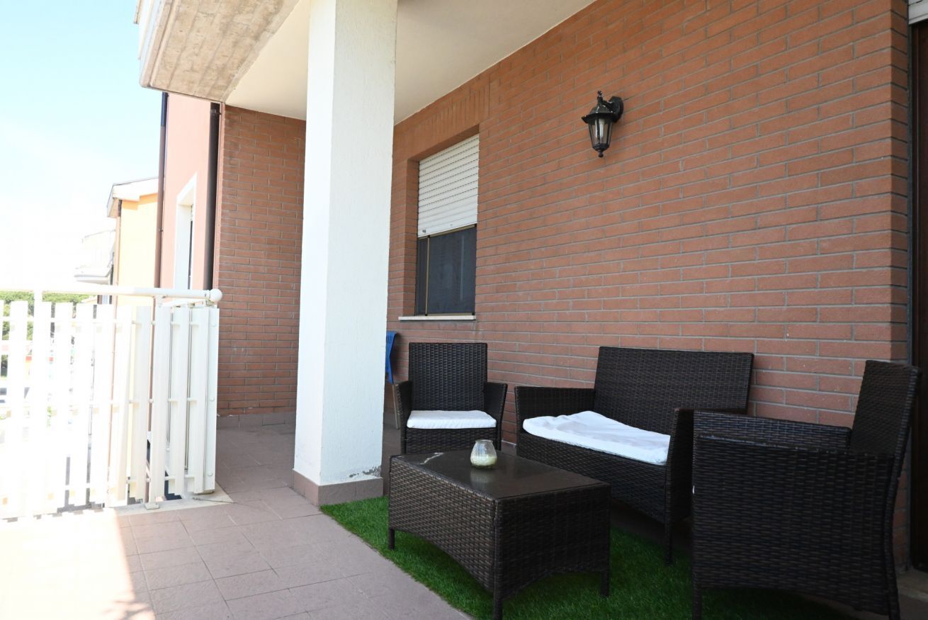 Un patio con muebles de mimbre, una mesa y una pared de ladrillo.