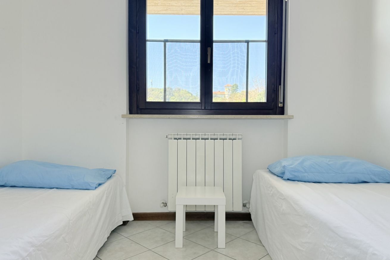 Una habitación con dos camas, un radiador y una ventana.