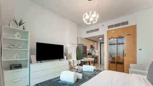 Une chambre d’hôtel moderne équipée d’un lit, d’une télévision, d’un bureau et d’une armoire.