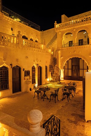 Un patio con una fuente, un área de descanso y arquitectura decorativa.