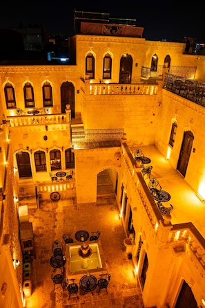 Un patio con una fuente, zonas de estar y arquitectura tradicional.