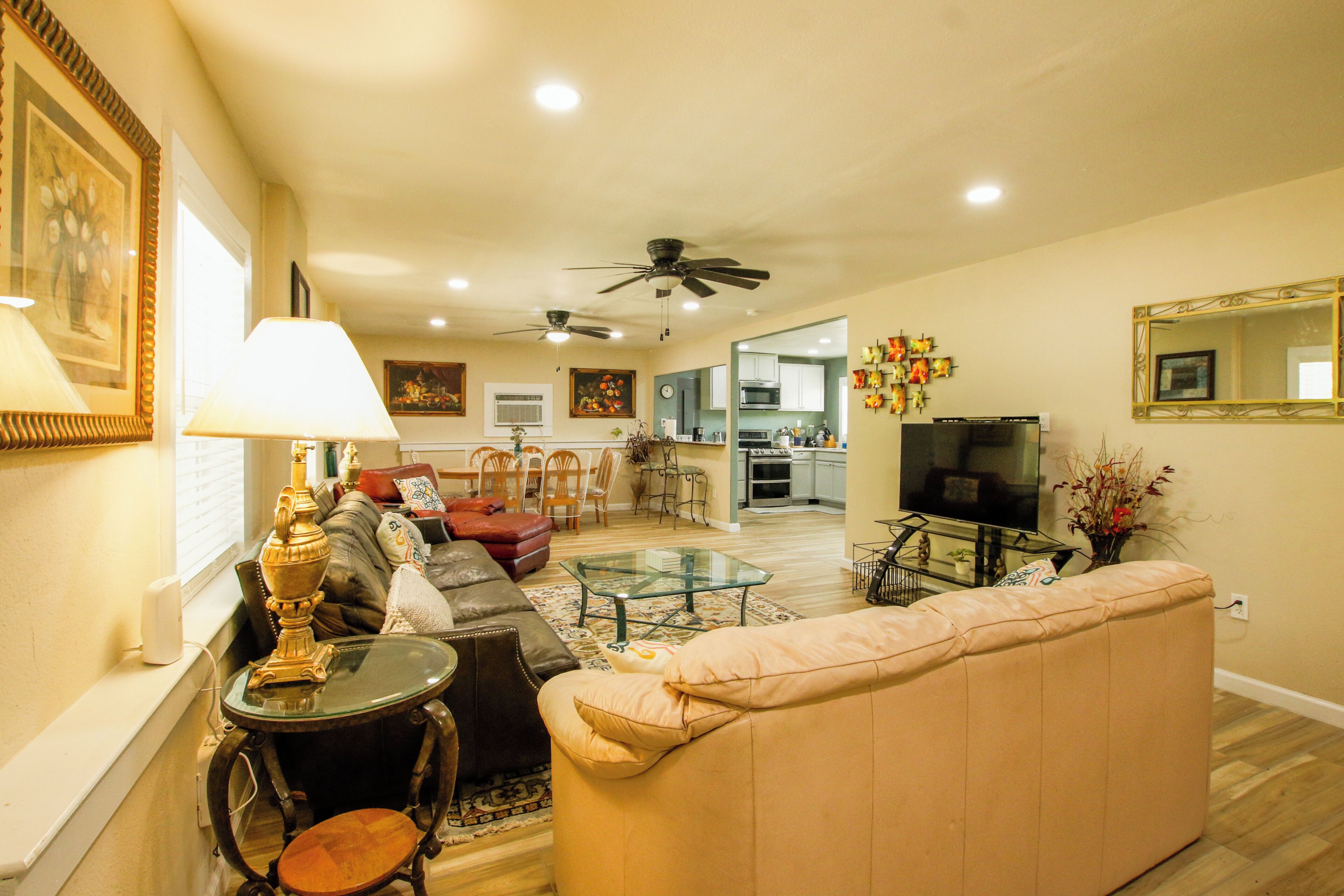 A living room with a sofa, a glass coffee table, a lamp, and a television.
