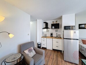 A compact kitchen with a refrigerator, microwave, and coffee maker. - Bright studio with balcony - 2 guests (Lamalou-les-Bains)