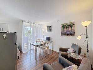 Una sala de estar moderna con una mesa de comedor, sofá y televisor.