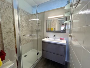 A modern bathroom with a glass-enclosed shower, a vanity with a sink, and a mirror above the vanity. - Apartment with AC, panoramic view - 4 guests (Argelès-sur-Mer)