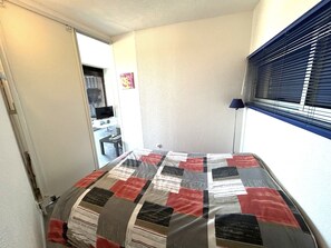 A bedroom with a bed, a desk, a chair, a television, and a window with blinds. - Apartment with AC, panoramic view - 4 guests (Argelès-sur-Mer)