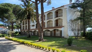 A building with multiple balconies, a paved driveway, and a well-maintained lawn with small bushes. - Apartment near beach - 4 guests (Argelès-sur-Mer)