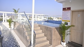 A rooftop pool area with a sign indicating swimming pool rules and pool timings. - Royal Residency Udaipur (Udaipur)
