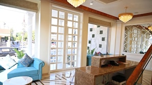 A modern hotel lobby with a blue sofa, a marble reception desk, and a staircase. - Royal Residency Udaipur (Udaipur)