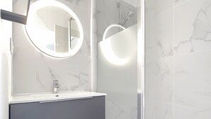 Ein Badezimmer mit Spiegel, Waschbecken und Dusche.