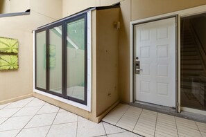 A residential building with a sliding glass door, a white door, and a tiled floor. - 3 Bedroom Townhome in Beachwalk (Miramar Beacn)