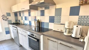 Een moderne keuken met een roestvrijstalen fornuis, een ingebouwde oven, een broodrooster en een koffiezetapparaat.
