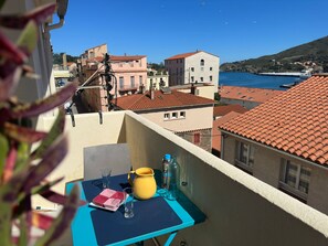 A balcony with a table, a yellow pitcher, and clear glasses. - Air-conditioned apartment, port view - 6 guests (Port-Vendres)