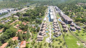 Et resort med flere bungalows, et fælles poolområde og frodig vegetation omkring.
