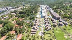 Ein Resort mit mehreren Bungalows, einem zentralen Poolbereich und umliegender Bepflanzung.