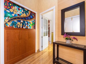 A hallway with a wooden door, a stained glass window, and a mirror on the wall. - Cozy apartment in the heart of Granada - 4 guests (Granada)