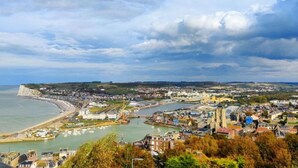 Una località costiera con una chiesa imponente, un porto con barche e una scogliera.
