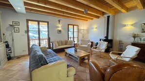 Una sala de estar acogedora con un sofá, sillas, una mesa de centro y una chimenea.