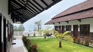 A covered outdoor area with a tiled roof, a grassy lawn, and potted plants. - Bawangan Express  (Ngadisari)