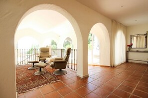Ein geräumiges Zimmer mit Balkon, großem Fenster und einem Bett mit Nachttisch.