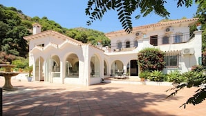 A two-story building with a courtyard, arched walkways, and a garden area. - Seven bedroom villa in Ojen near Marbella (Ojen)