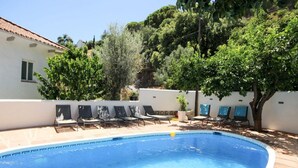 A swimming pool with lounge chairs, a white building, and trees in the background. - Seven bedroom villa in Ojen near Marbella (Ojen)