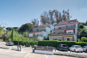 Un edificio residenziale a più piani con un design architettonico moderno, caratterizzato da balconi e un ingresso con cancello.